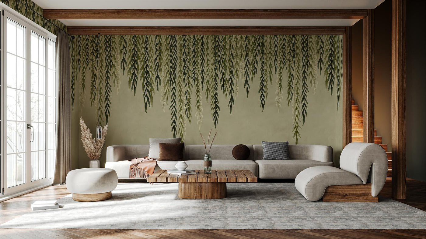Green leaved wall mural on the wall of this livingroom. Grey rug. Brown wooden floor. Grey sofa and wooden table