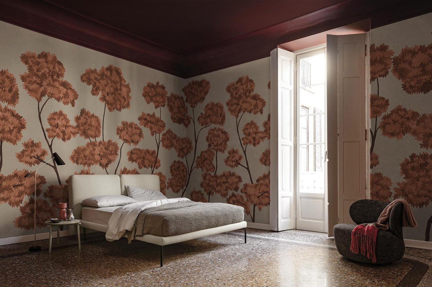 red and wall mural on the back wall of this bedroom. Beige and white bed with linnen bedding. Wooden floor. 